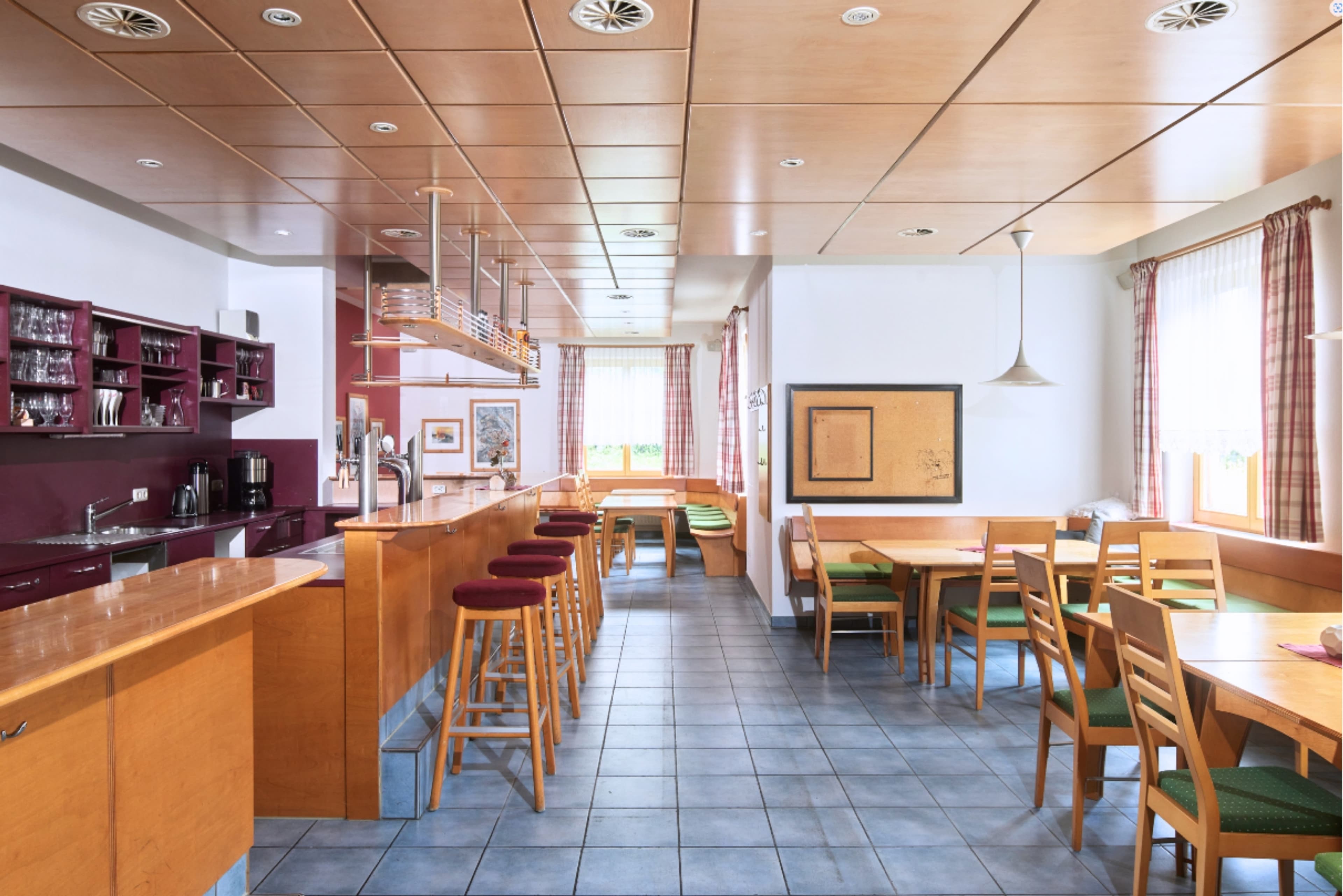 Holiday Home Zapfig Living - A bright and airy bedroom with two beds, bunk beds, and a desk. The room is filled with natural light from the windows, which have colorful curtains.